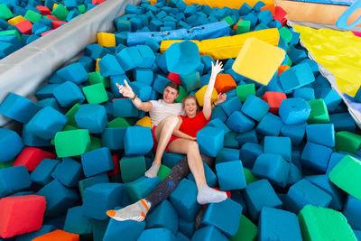 High angle view of boy playing with multi colored umbrellas