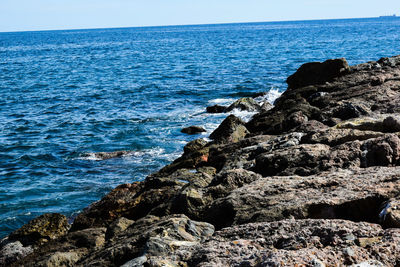 Rock formation on beach against sky