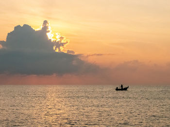 Silhouette boat in sea against sky during sunset
