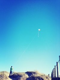 Low angle view of man standing on landscape against clear sky