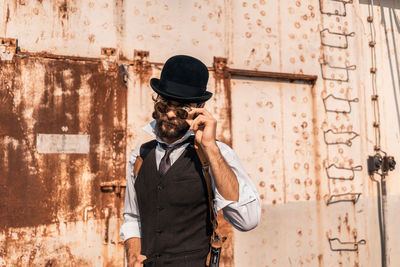 Full length of man photographing against wall