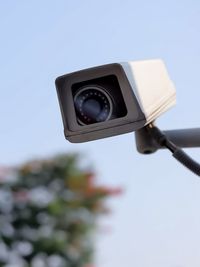 Low angle view of security camera against sky