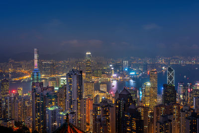 Illuminated cityscape against sky at night