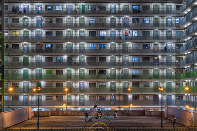 Public park against buildings in city at night