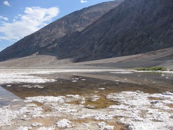 Scenic view of salt lake by mountain against sky