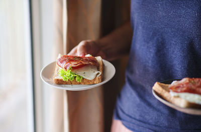 Midsection of woman holding ice cream in plate