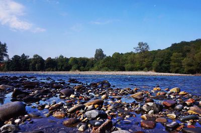 Pebbles on water against sky