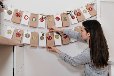 Mother opening christmas advent calendar tasks and gifts. woman excited about festive surprise 