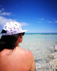 Rear view of shirtless woman at beach