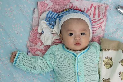 Portrait of cute baby lying on bed