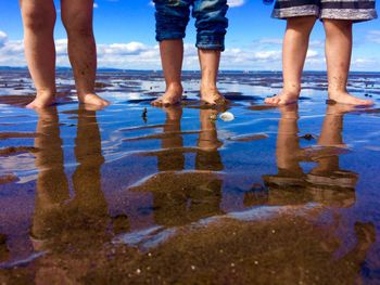 Low section of people standing on beach