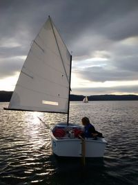 Boat sailing in sea at sunset