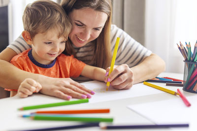 Boy drawing on book at home