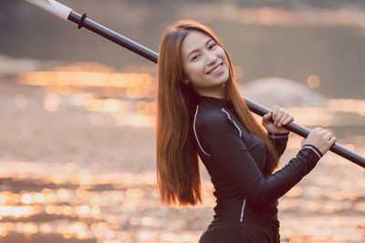 Young woman standing against sea