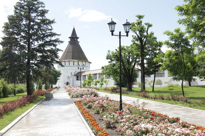 Street amidst trees and temple against sky