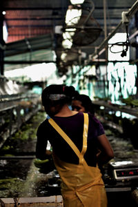 Rear view of a man holding umbrella