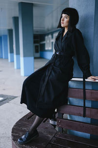 Woman in a black coat sitting on a bench