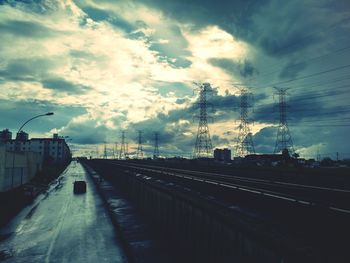 Railroad tracks against cloudy sky