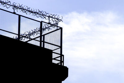 Low angle view of silhouette staircase against sky