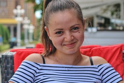 Portrait of smiling woman sitting at sidewalk cafe