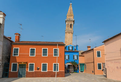 Buildings in city against blue sky