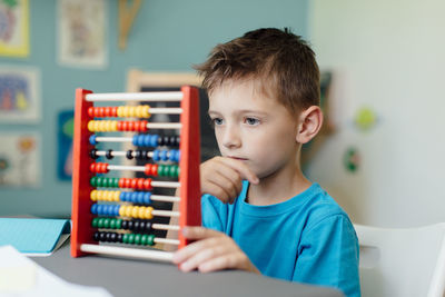 Portrait of boy using abacus