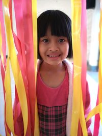 Portrait of smiling girl standing by multi colored decoration