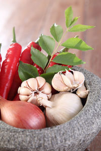 High angle view of spices with vegetables in mortar on wooden table