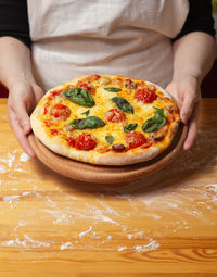 Close-up of hand holding pizza