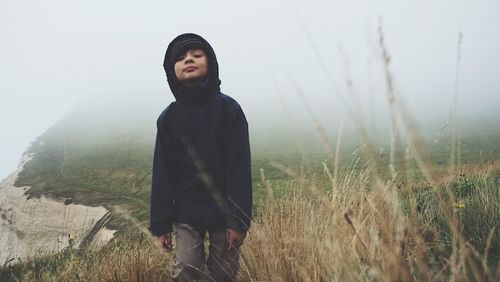 Man looking at camera on field during foggy weather