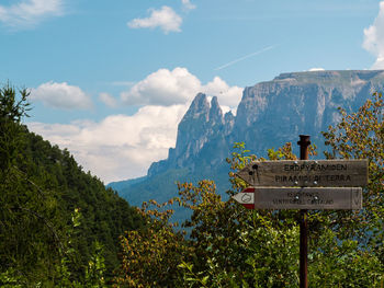 Information sign on mountain against sky