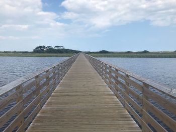 Pier over lake against sky