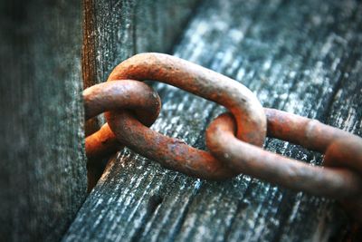 Close-up of rusty chain on wood