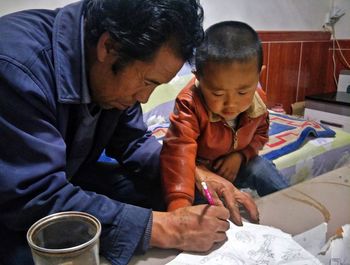 Father assisting son while studying at home