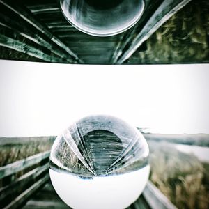 Close-up of crystal ball on glass against blurred background