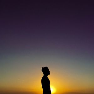 Silhouette of man standing against sky during sunset