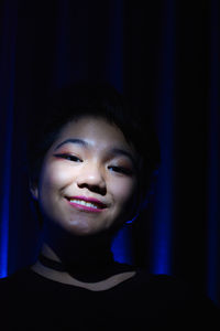 Low lit portrait of a young girl with colored light as accent