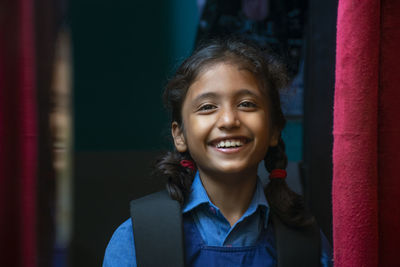 Portrait of smiling girl standing at home