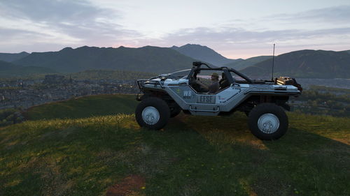 Vintage car on field by mountains against sky