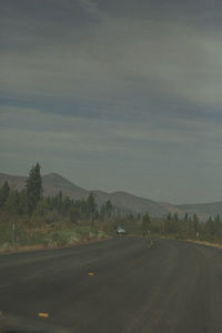 Road by mountain against sky