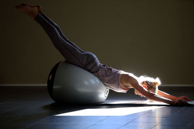 Woman exercising with medicine ball in yoga class