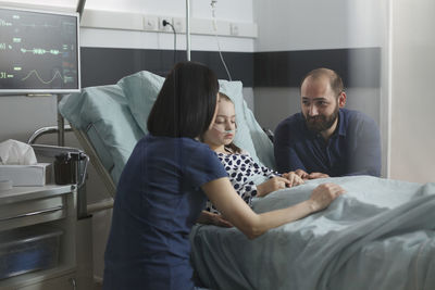 Side view of doctor examining patient in clinic