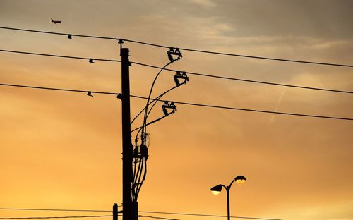 Low angle view of silhouette street light against sky