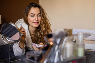 Portrait of smiling young woman drinking glass