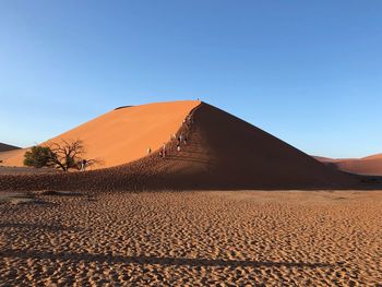Scenic view of desert against clear blue sky