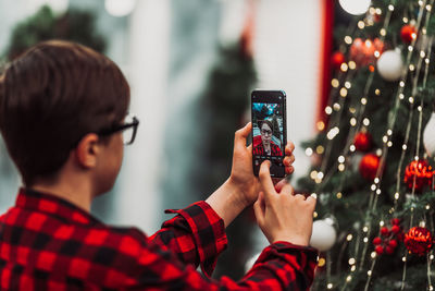 Portrait of man photographing with mobile phone