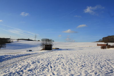 Scenic view of snow covered field against sky