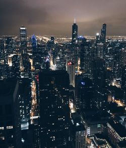 Illuminated cityscape against sky at night