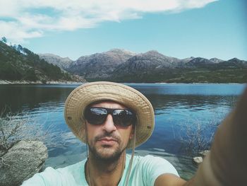 Portrait of young man in lake against mountains