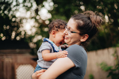 Smiling mother and son sitting outdoors